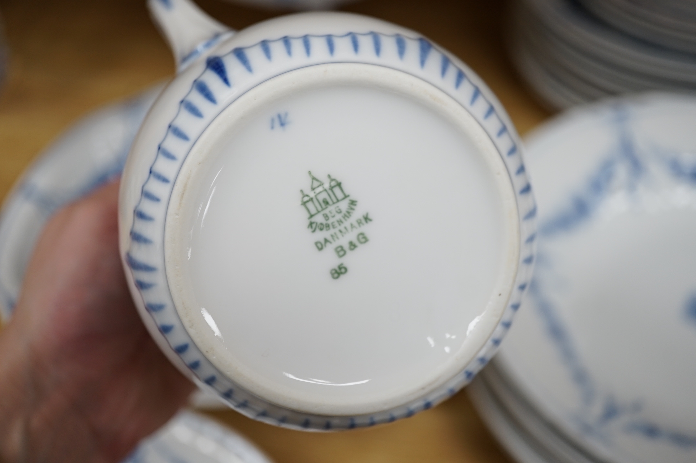 A Bing and Grondahl, Denmark blue and white ‘Empire’ pattern dinner service, thirty-eight pieces including; a cake, stand, candlestick, dinner, plates, jug, serving, dishes, etc.